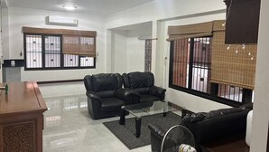 A modern living room with a sofa set, a glass coffee table, and a fan. - great villa for a great holiday (จ.ภูเก็ต)