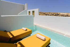 Zona de piscina con dos tumbonas amarillas, una con una toalla.