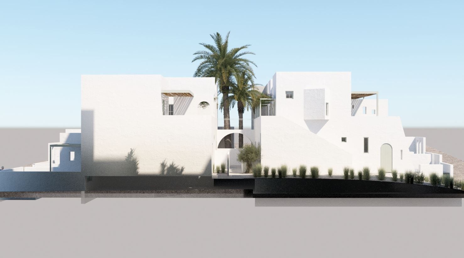 Um edifício moderno e branco com uma palmeira, um pequeno jardim e um céu claro.