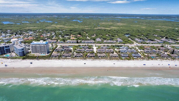 An aerial view of a coastal residential area with beachfront properties, a large hotel, and a beach. - Luxury / Beachside / Pickle Ball / Surf / Pool (New Smyrna Beach)