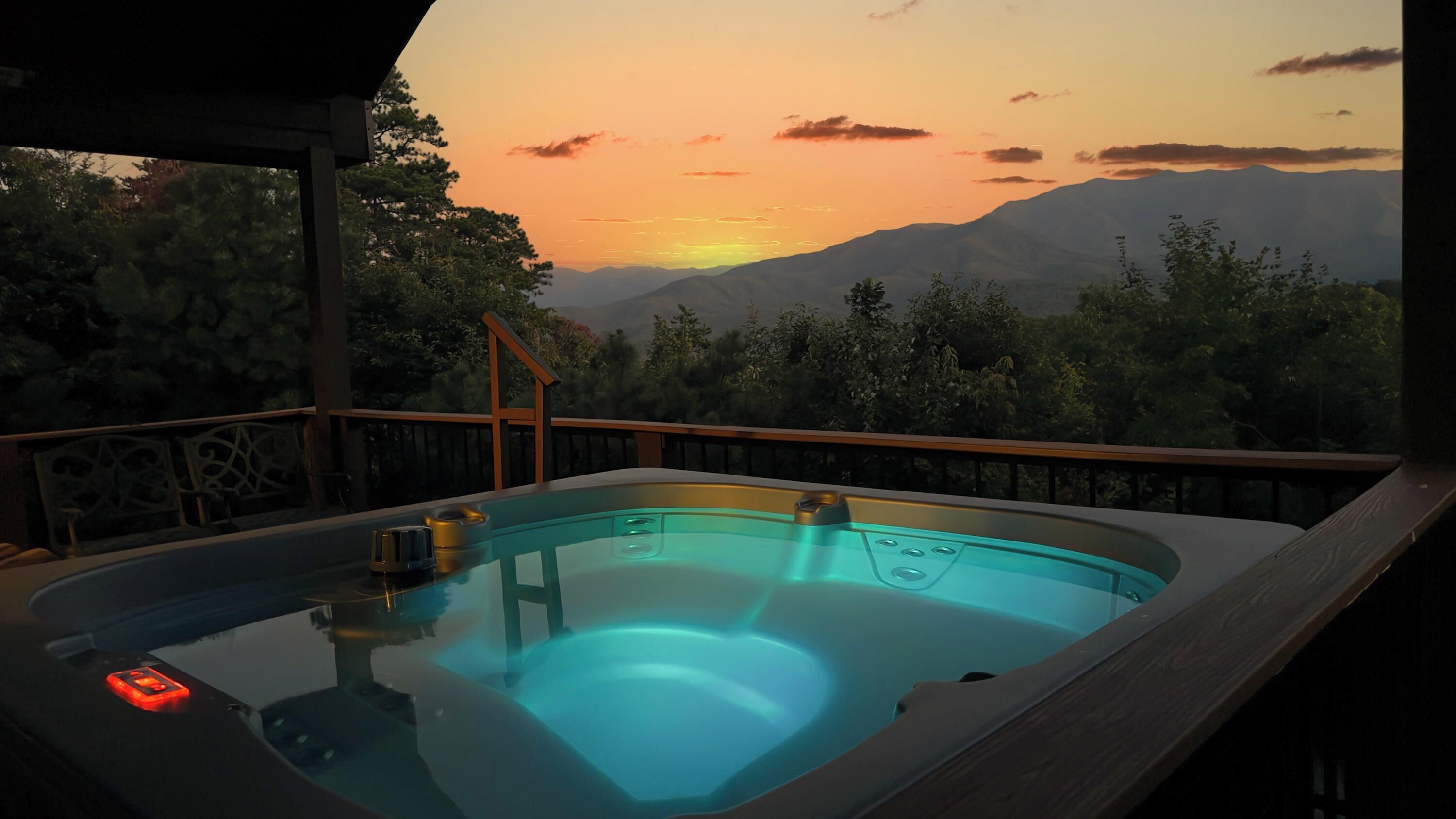 A hot tub with a view of mountains and trees at sunset.