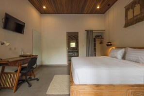 Un dormitorio con cama, escritorio, silla, televisor y armario.