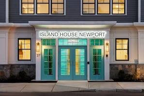 Entrada de un hotel con puertas color turquesa y un letrero que dice 'ISLAND HOUSE NEWPORT'.