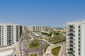 Een modern wooncomplex met hoge gebouwen, een centrale rotonde en een parkeerplaats.