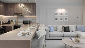 A modern kitchen with a central island, a dining area with a sofa, and a living room with a coffee table. - Modern Living w/ Premium Amenities close to Marina (Dubai)