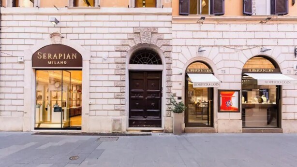 A building facade with storefronts named "Serapian Milano" and "Roberto Coin." - Central Rome Apartment Near Piazza del Popolo
 (Roma)