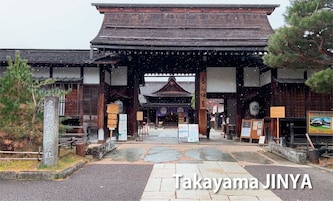 Un edificio tradicional japonés con entrada de madera y sendero de piedra.