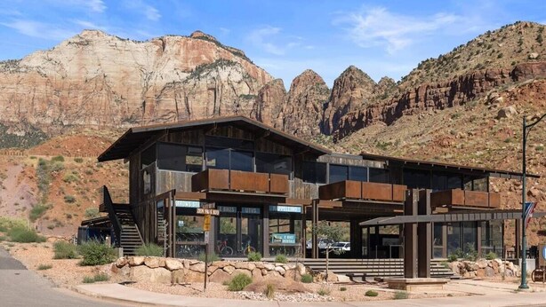 A modern building with a rustic exterior, large windows, and a stone foundation. - Zion Lofts  Unit 4 Su (Springdale)