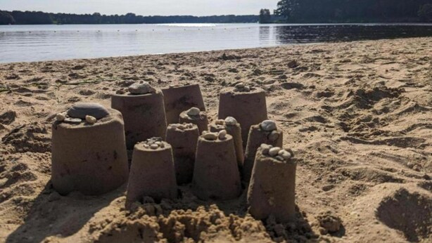 Una playa arenosa con varias esculturas de arena.
