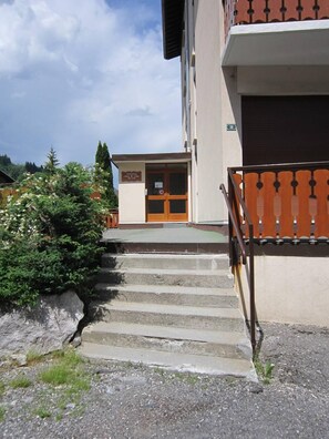 A building with a staircase leading to a door marked 'Attention concierge.'