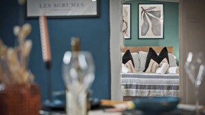 A room with a bed, a framed sign on the wall, and abstract art.