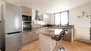 Una cocina moderna con horno empotrado, microondas y refrigerador de acero inoxidable.