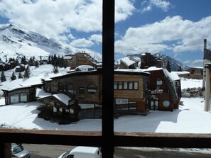 Un bâtiment en bois, sur lequel on peut lire l’inscription « BISTRO », situé dans un paysage montagneux enneigé.