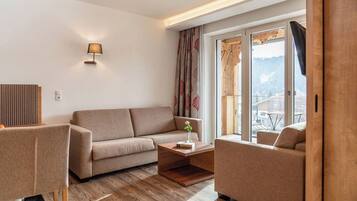 Suite junior | Área de sala de estar | Televisión de pantalla plana de 54 cm con canales por cable