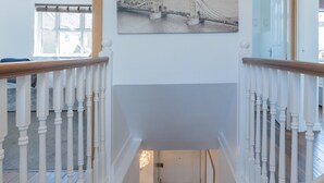 A staircase with white balusters and a wooden handrail leading to a landing.