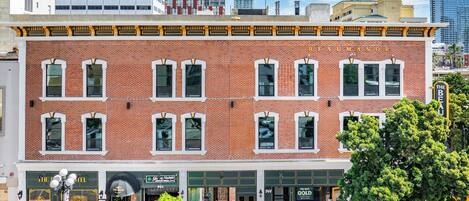A brick building with a row of windows and a sign that reads "The Beau Hotel".