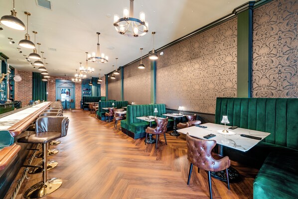 A restaurant with green booths, wooden bar stools, and pendant lighting. - The Beau Hotel Gaslamp Quarter San Diego (San Diego)