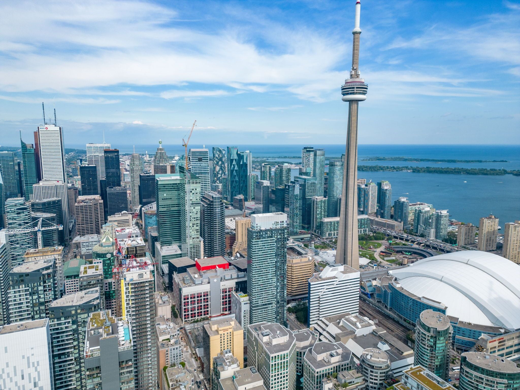 A high-rise cityscape with modern architecture, including a prominent tower and a large stadium.