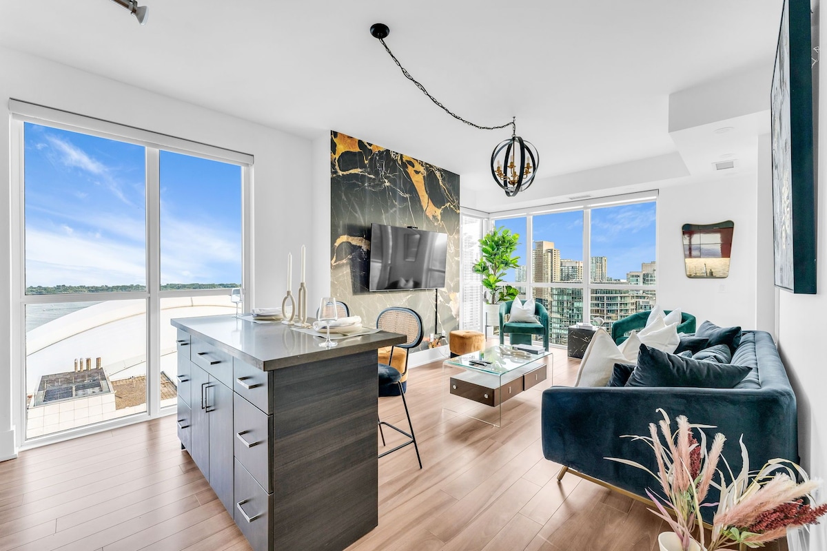 A modern living space with a kitchen, dining area, and a sofa set.