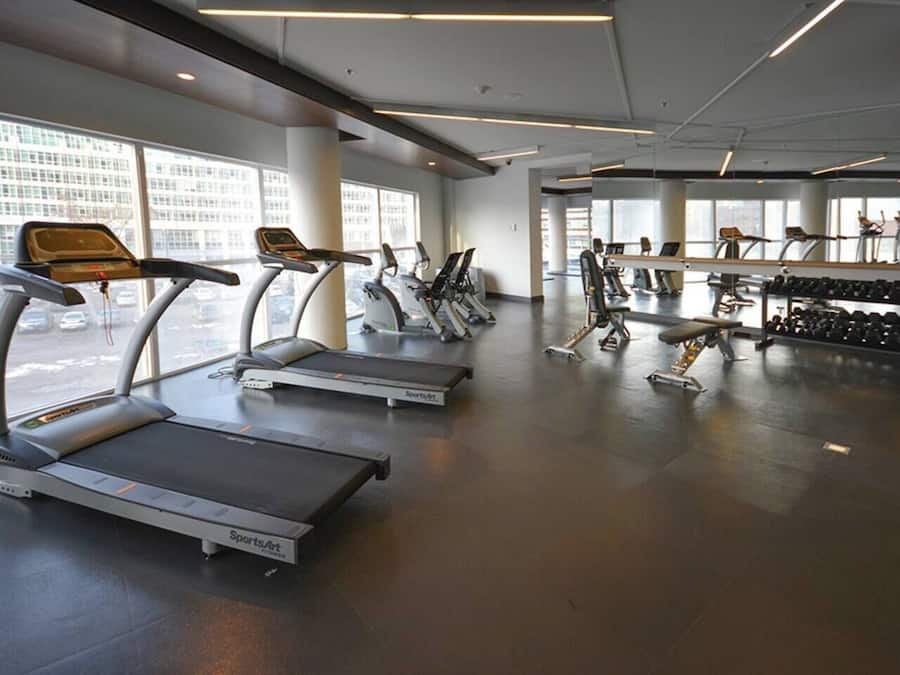 Un gimnasio con cintas de correr, elípticas y bancos de pesas.