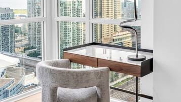Un espacio de oficina moderno con escritorio, silla y grandes ventanales con vistas a un paisaje urbano.