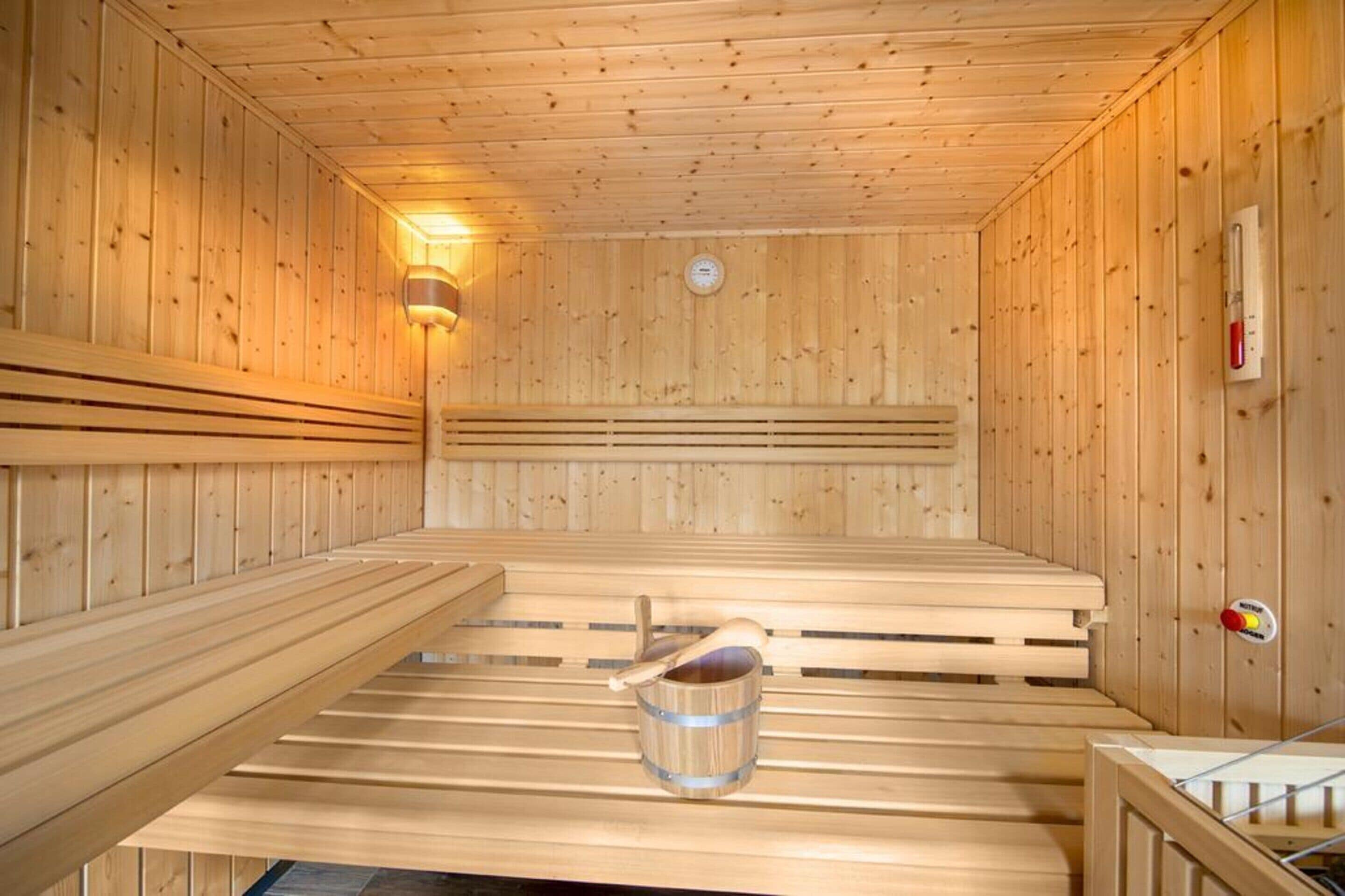 Un sauna avec des bancs en bois et un seau.