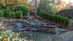 Un espace extérieur aménagé avec des murs en pierre et une terrasse dallée.