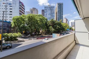 A city street with buildings, trees, and a clear sky. - Duque by My Way (Porto Alegre)