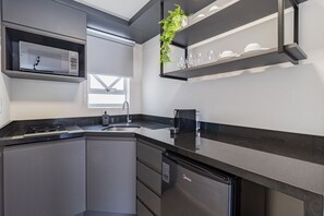 Une cuisine moderne équipée d’un four à micro-ondes encastré, d’un évier et d’un lave-vaisselle.