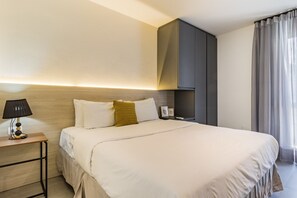 A hotel room with a bed, bedside table, lamp, and a wardrobe. - Duque by My Way (Porto Alegre)