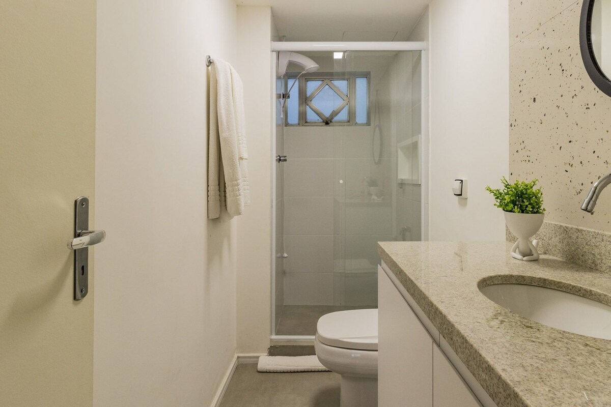 Une salle de bain avec douche, toilettes et lavabo.