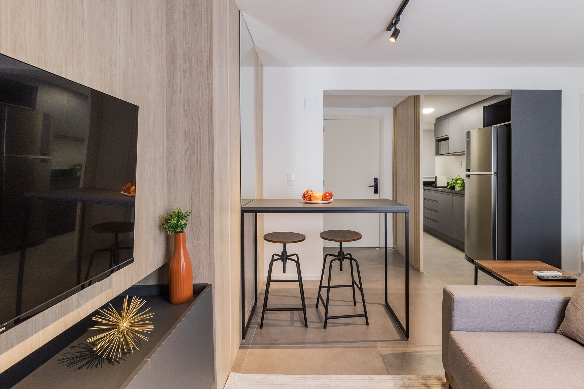 Une cuisine moderne avec un coin repas, un téléviseur et un canapé.