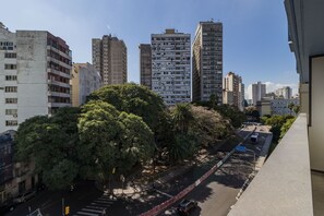 A city street with tall buildings, trees, and a pedestrian crossing. - Duque by My Way (Porto Alegre)