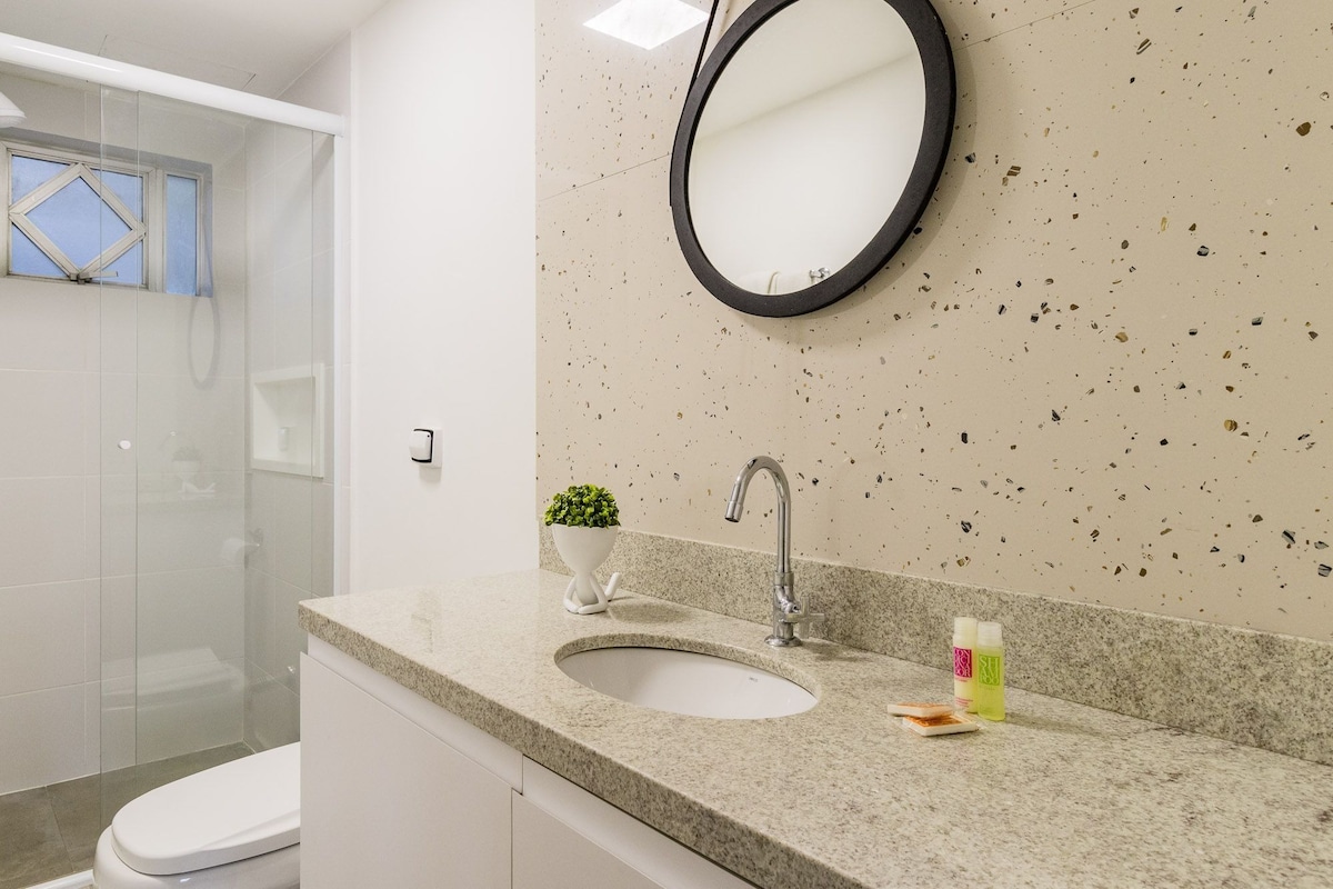Une salle de bain équipée d’un lavabo, d’un miroir et d’une zone douche.
