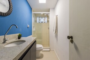 A bathroom with a sink, toilet, and shower. - Duque by My Way (Porto Alegre)