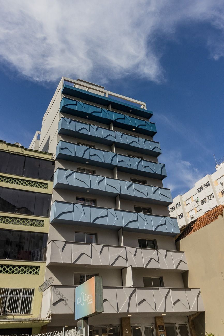 Ein mehrgeschossiges Gebäude mit modernem architektonischen Design, mit Balkonen auf jeder Etage.