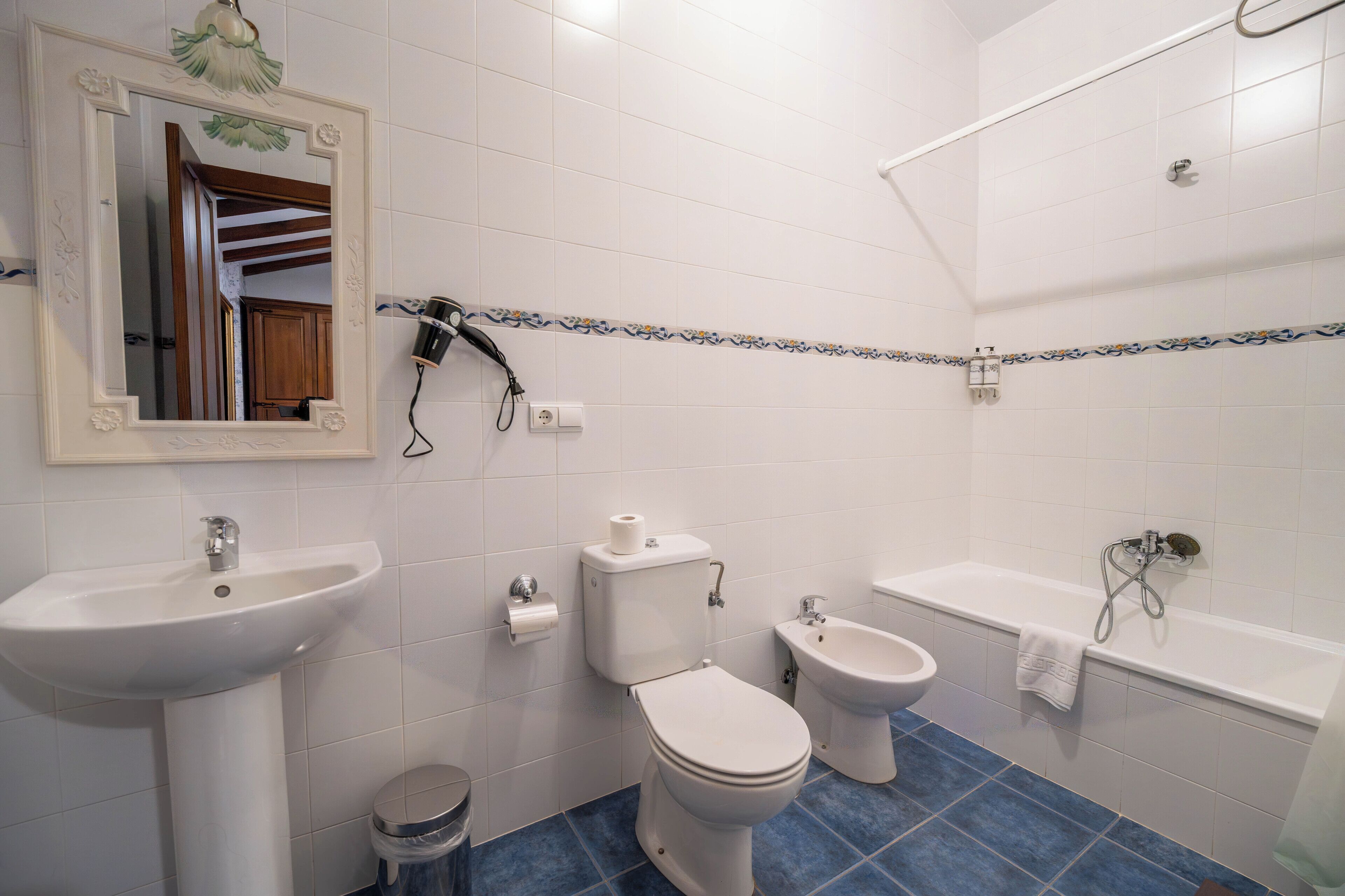 A bathroom with a sink, toilet, bidet, and bathtub.