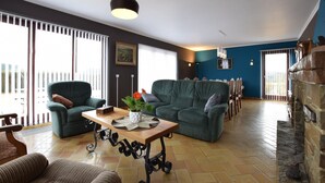 Una sala de estar con un sofá verde, una mesa de centro de madera y una chimenea.