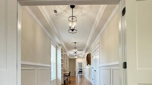 A long, narrow hallway with wooden flooring and white walls. - Richmond Ridge - 4BD/4.5BA and Garage (Richmond)
