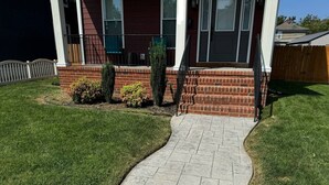 A house with a stone pathway leading to the front door, surrounded by a well-maintained lawn and a wooden fence. - Richmond Ridge - 4BD/4.5BA and Garage (Richmond)