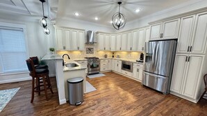 A spacious kitchen with white cabinetry, stainless steel appliances, and a wooden floor. - Richmond Ridge - 4BD/4.5BA and Garage (Richmond)