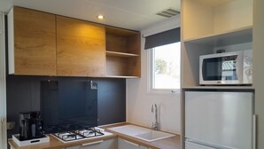 Una cocina compacta con estufa a gas, microondas y refrigerador.