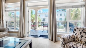 Un'ampia zona giorno con ampie finestre, un balcone con sedie e un divano.