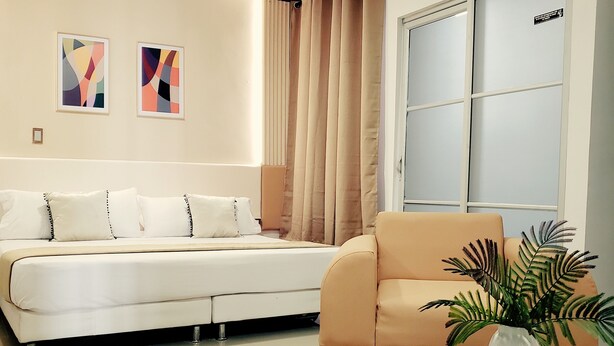 A modern living room with a sofa, a coffee table with a plant, and a wardrobe. - HOTEL SUITE CENTER (Pereira)