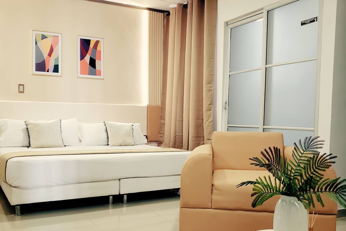 A modern living room with a sofa, a coffee table with a plant, and a wardrobe.