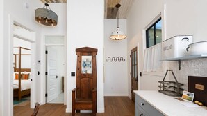 A modern kitchen with a wooden cabinet, a hanging light fixture, and a bread box on the counter. - Jasmine residence, located downtown between the Union Hotel & Bells restaurant. (Los Alamos)