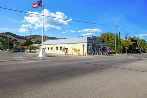 Un edificio a due piani con tetto piatto, un'asta con bandiera americana e cielo azzurro limpido.