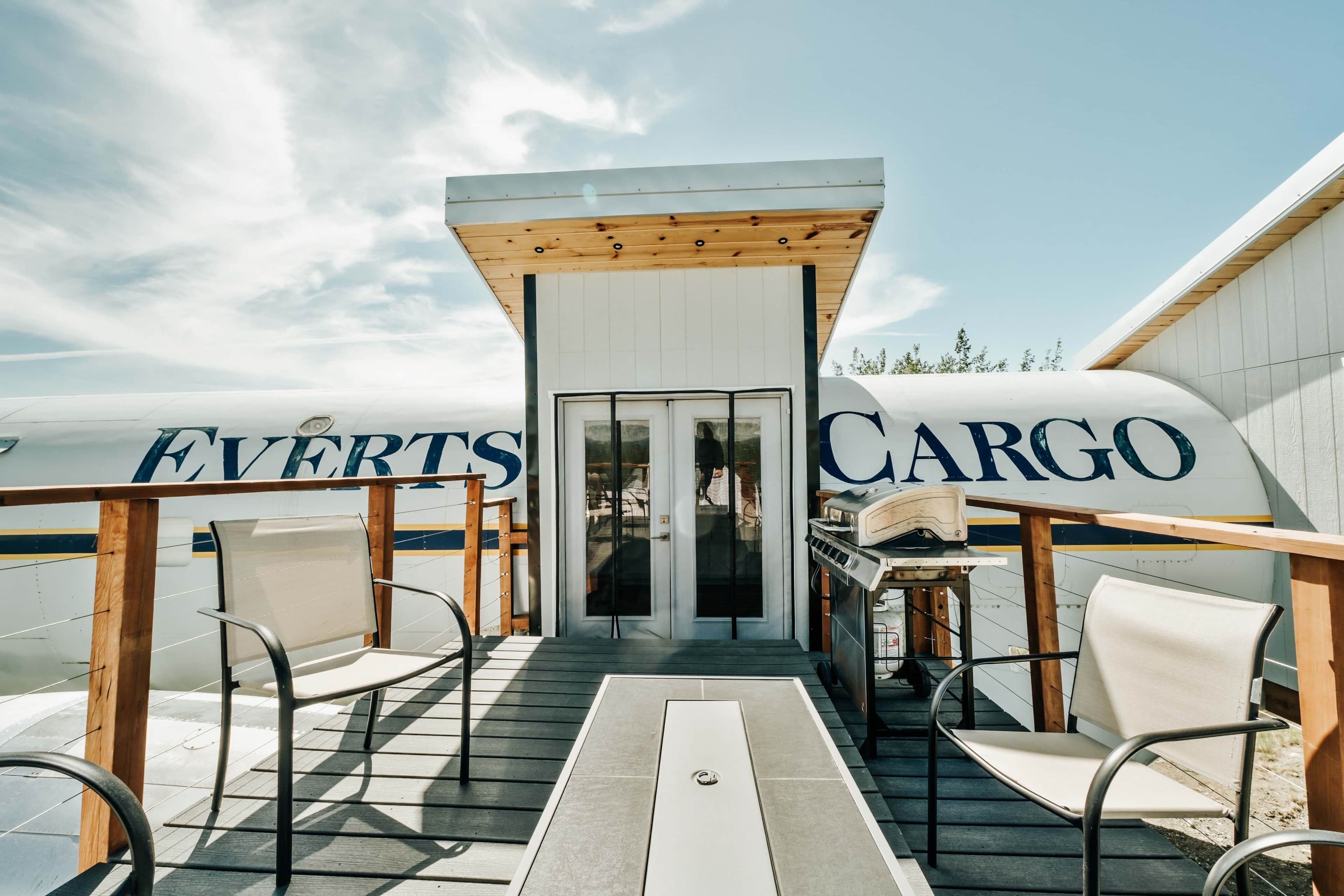 A cargo ship with 'EVERTS CARGO' written on its side, a covered deck with chairs, and a small table.