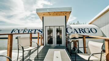 A cargo ship with 'EVERTS CARGO' written on its side, a covered deck with chairs, and a small table.