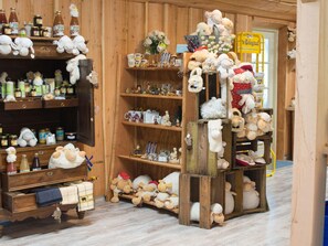 A store with wooden shelves filled with various items including jars, mugs, and stuffed animals. - Cozy Chalet Near a National Park (Ruinen)